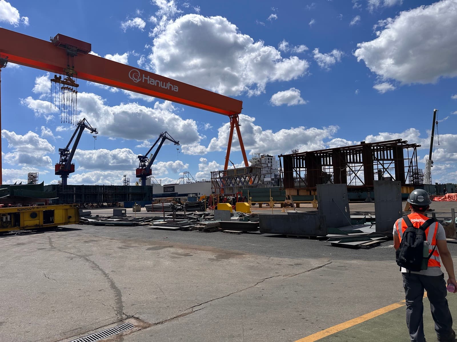 Technician walking through the steel fabrication yard at the Hanwha shipyard