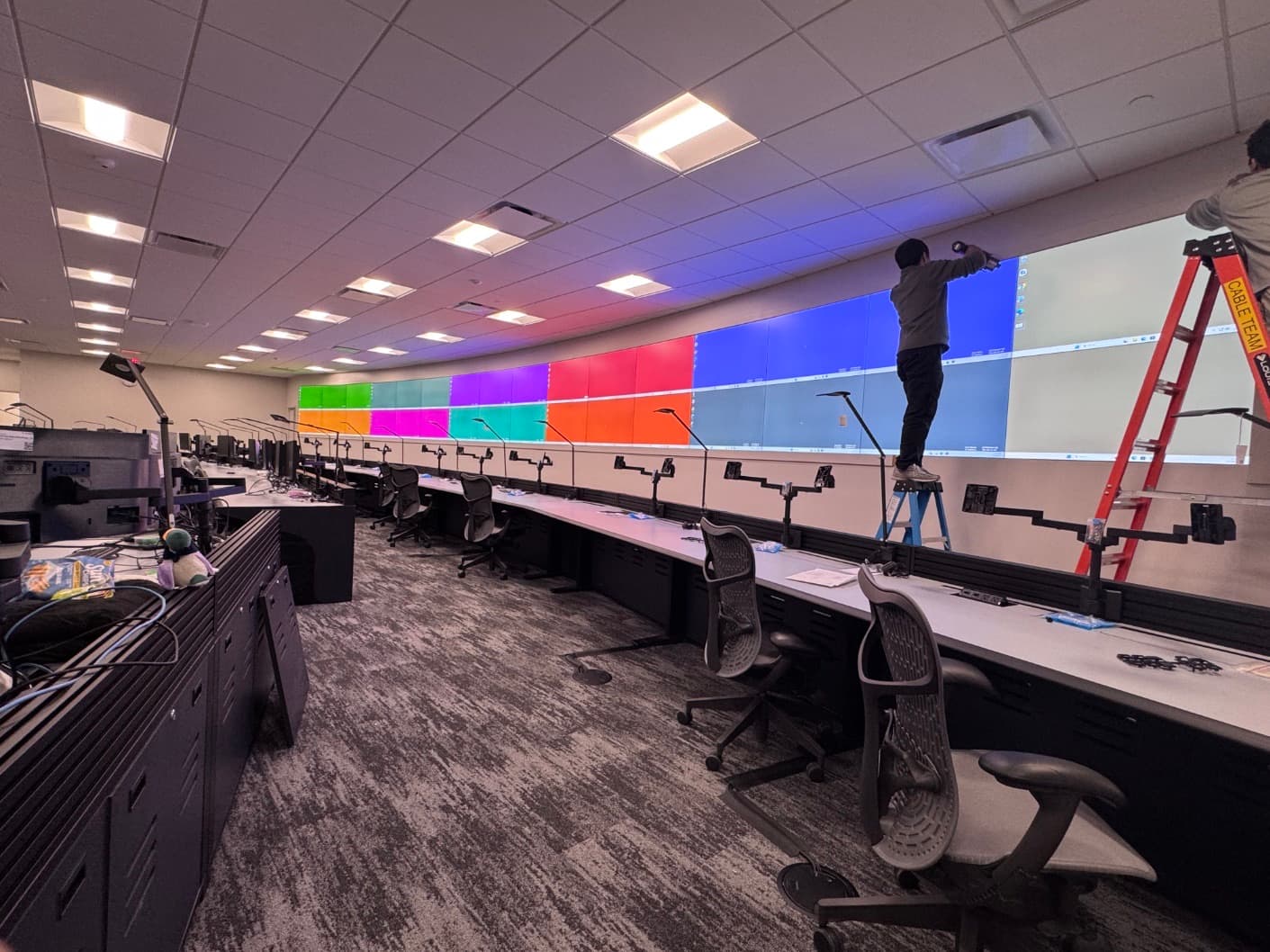 Technician calibrating video wall panels during a monitoring center build-out
