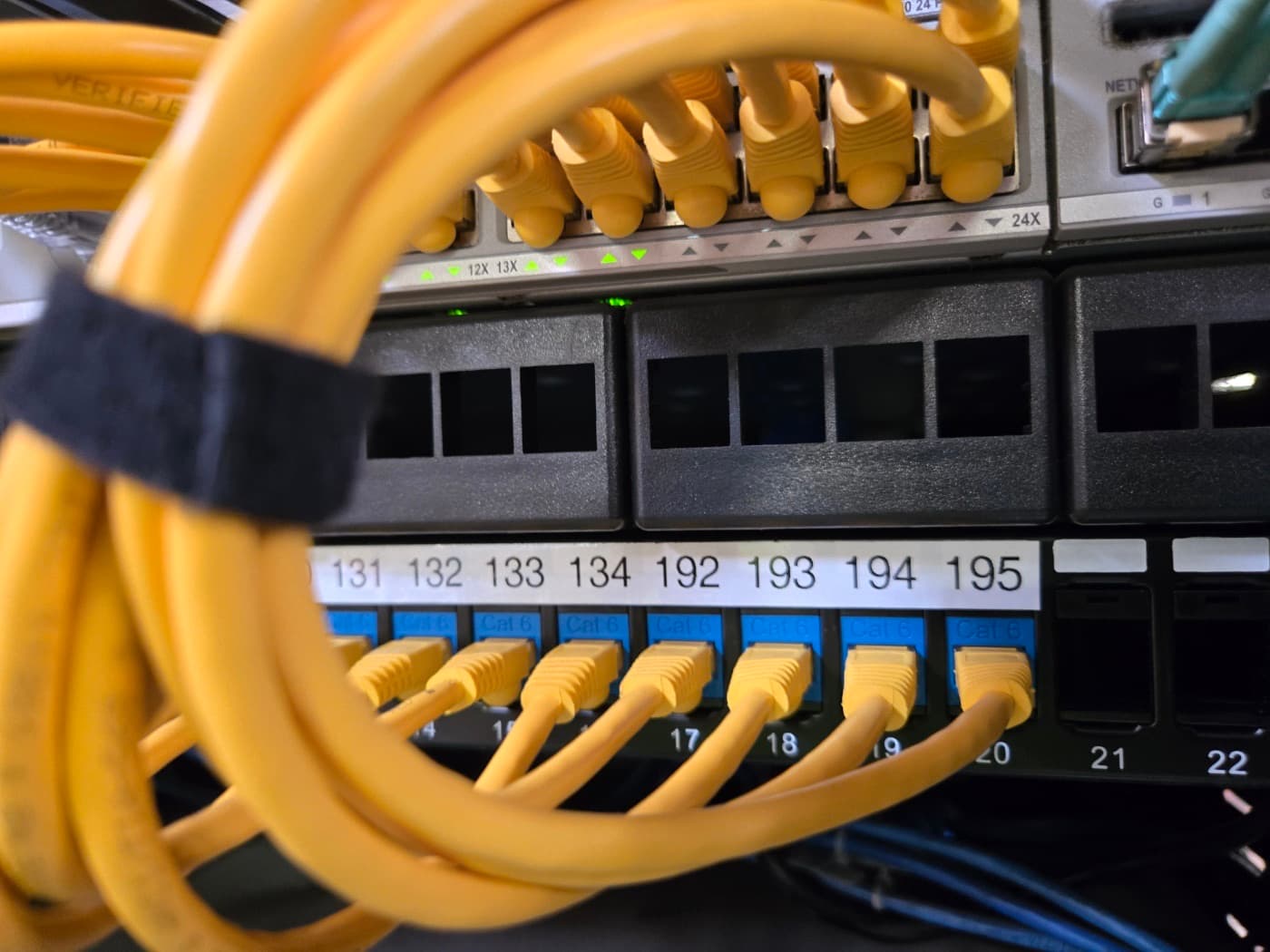 Close-up of labeled patch panel ports with cable management rings